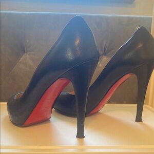 Black high-heeled stiletto pumps with pointed toe and glossy finish